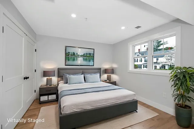a bedroom with a large bed and a potted plant