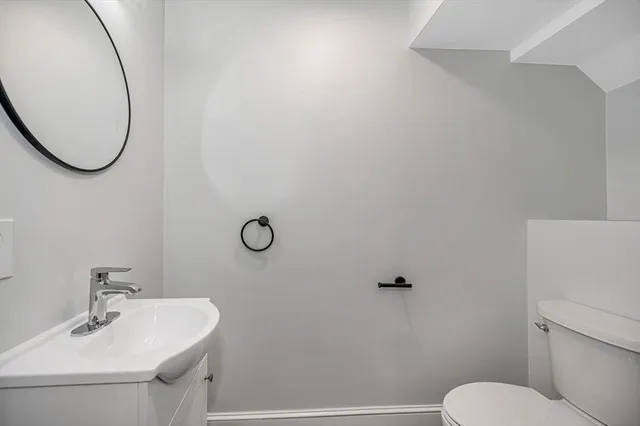 a bathroom with a sink mirror and toilet