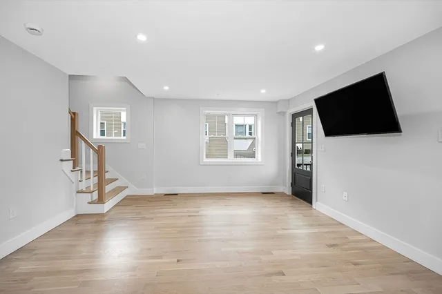 a view of a livingroom with wooden floor and a flat screen tv