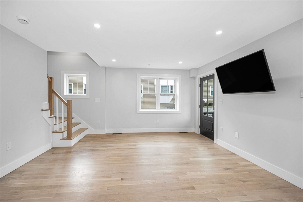 1514 Gorham Street, Unit 4 Lowell, MA 01852 - Photo 3 of 42 a view of a livingroom with wooden floor and a flat screen tv