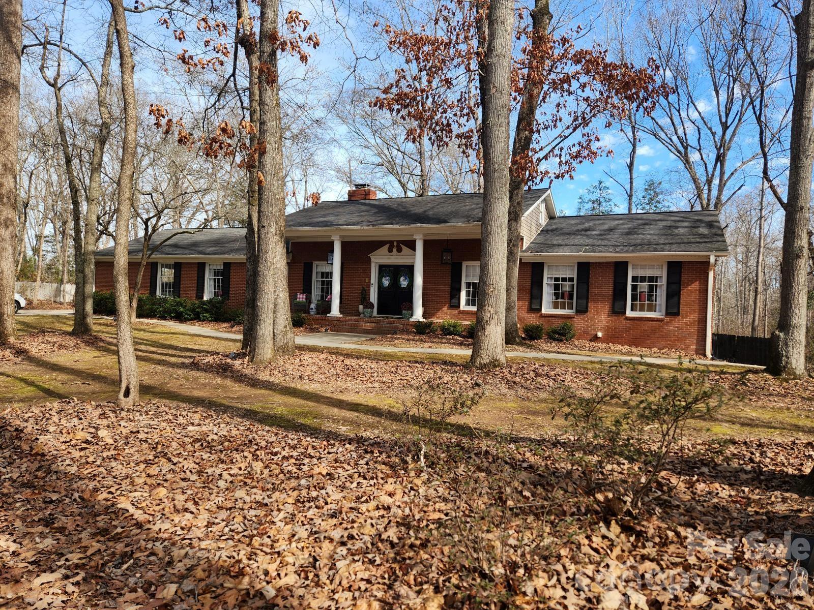 a front view of a house with a tree in front
