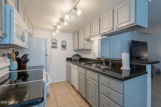 a kitchen with stainless steel appliances granite countertop a refrigerator and a stove top oven