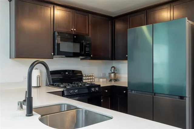 a kitchen with stainless steel appliances granite countertop a refrigerator and a stove top oven