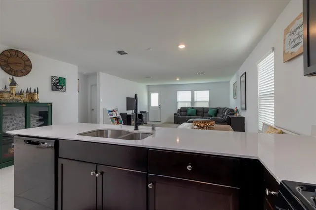 a view of a kitchen counter space a sink and living room view