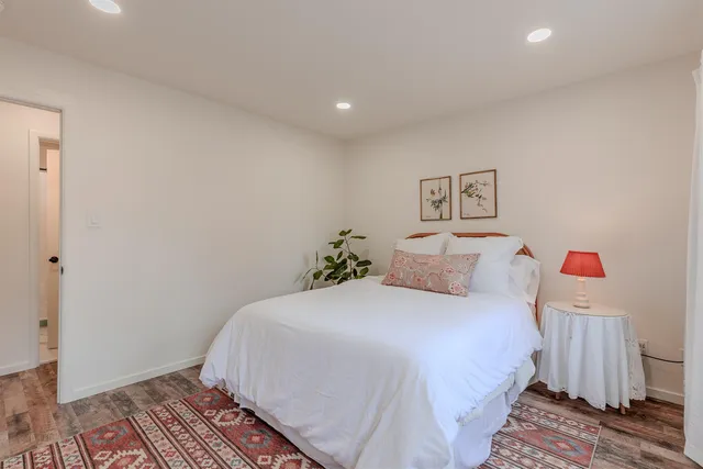 a bedroom with a bed and a painting on the wall