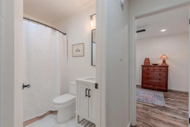 a bathroom with a toilet a sink and shower