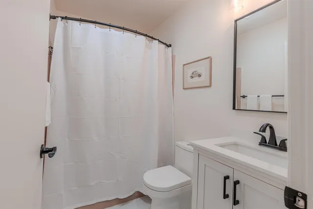 a bathroom with a sink a toilet and a mirror