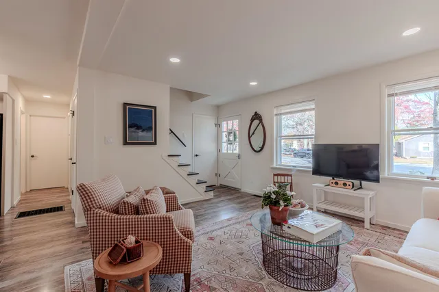 a living room with furniture a flat screen tv and a window