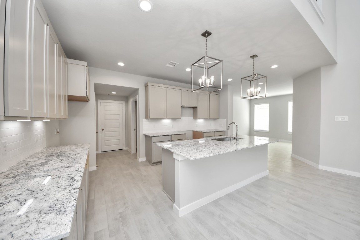 15802 Telge Ridge Lane Cypress, TX 77429 - Photo 23 of 45 a large kitchen with granite countertop a large counter top a sink stainless steel appliances and cabinets