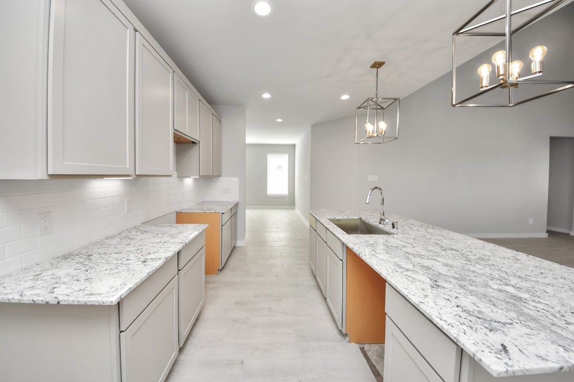 15802 Telge Ridge Lane Cypress, TX 77429 - Photo 24 of 45 a large kitchen with granite countertop a sink a counter top space and cabinets