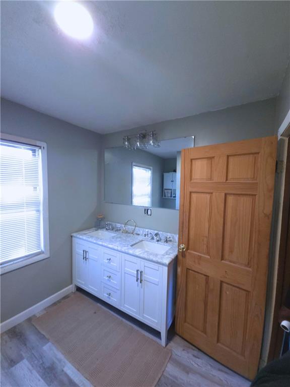 705 South State Line Road Sharon, PA 16146 - Photo 8 of 12 a room with a sink a mirror and wooden floor