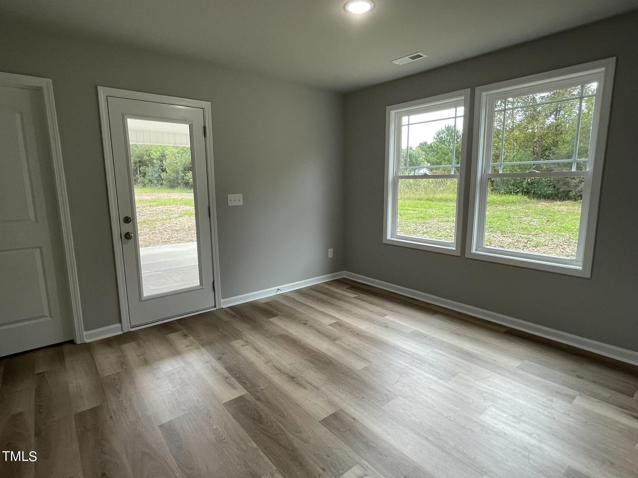 329 Ewing Drive Selma, NC 27576 - Photo 10 of 17 a view of empty room with wooden floor and fan