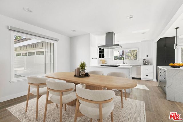 a kitchen with granite countertop white cabinets and chairs