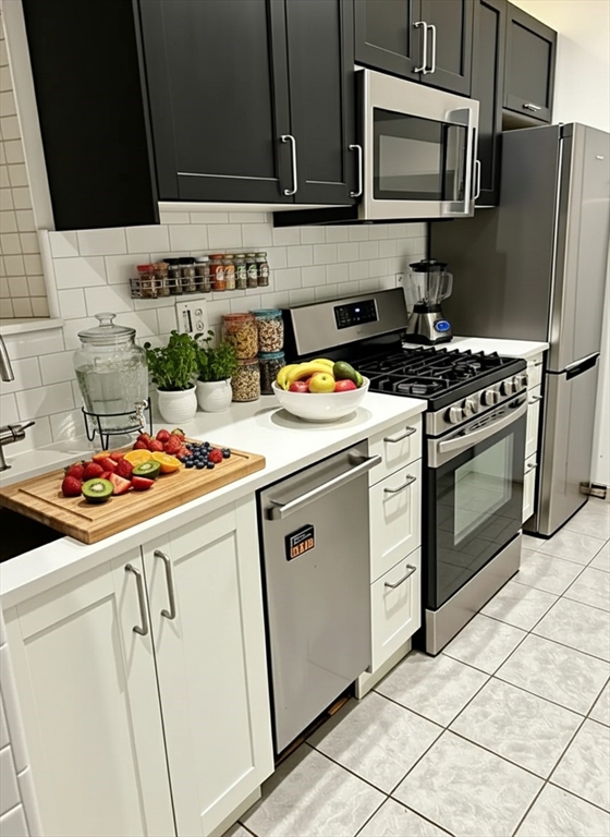 316 St Paul Street, Unit 5 Brookline, MA 02446 - Photo 5 of 7 a kitchen with stainless steel appliances a stove microwave and refrigerator