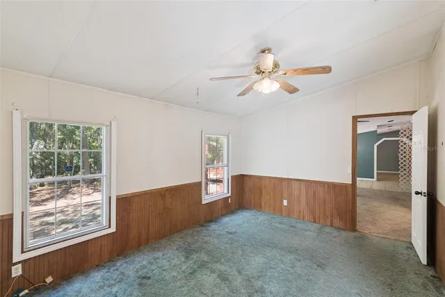 a view of a livingroom with a ceiling fan and window