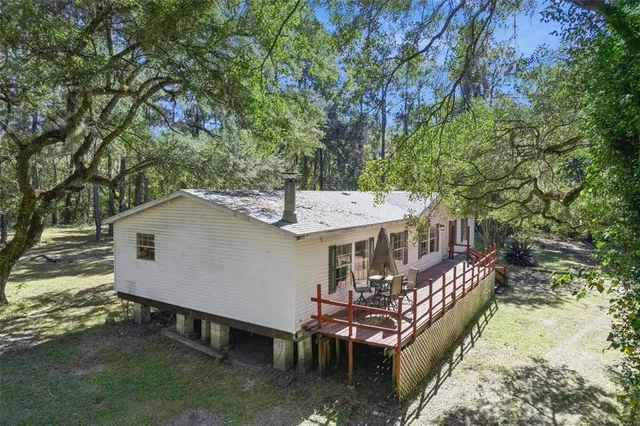 an aerial view of a house with swimming pool and deck