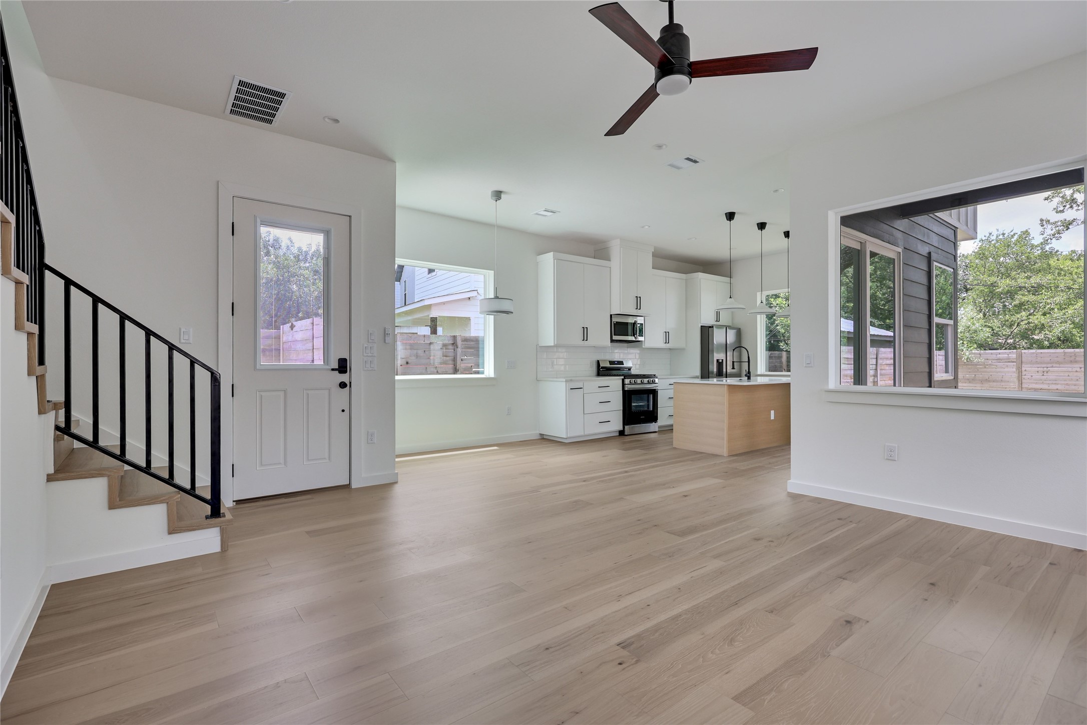 6809 Porter Street, Unit 2 Austin, TX 78741 - Photo 3 of 37 Clean lines and light-toned flooring define this open-concept living space with a modern kitchen and abundant natural illumination.