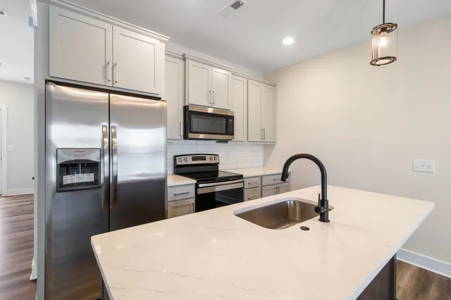 a kitchen with a refrigerator sink and stainless steel appliances