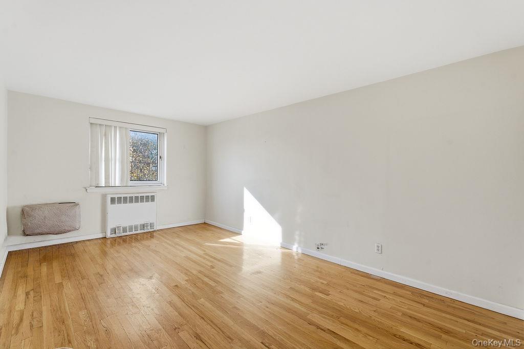 153-25 88th Street, Unit 4N Queens, NY 11414 - Photo 3 of 11 a view of an empty room with wooden floor and a window