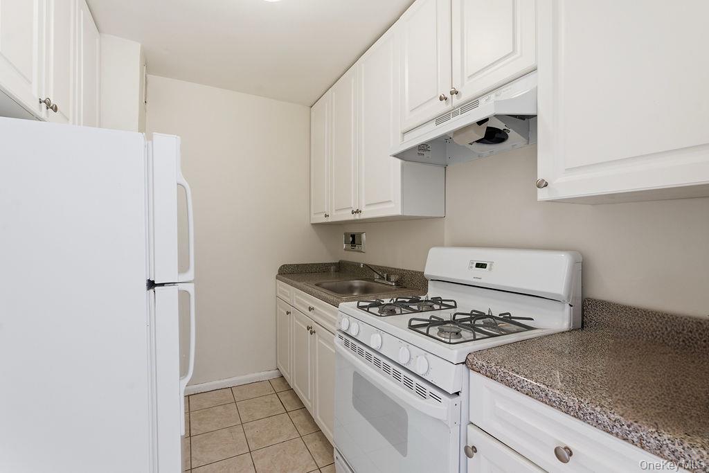 153-25 88th Street, Unit 4N Queens, NY 11414 - Photo 7 of 11 a white stove top oven sitting inside of a kitchen