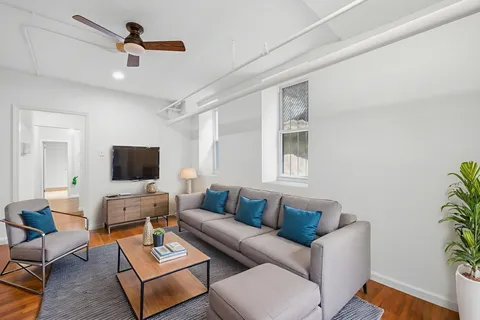 a living room with furniture a flat screen tv and a window