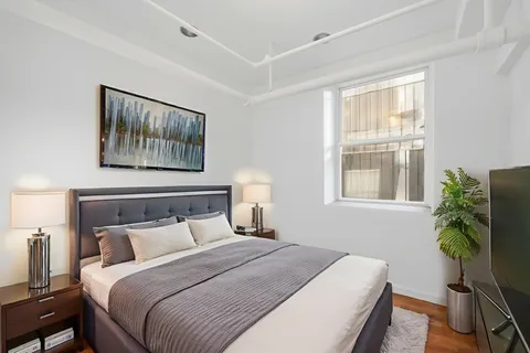 a bedroom with a bed and a painting on the wall