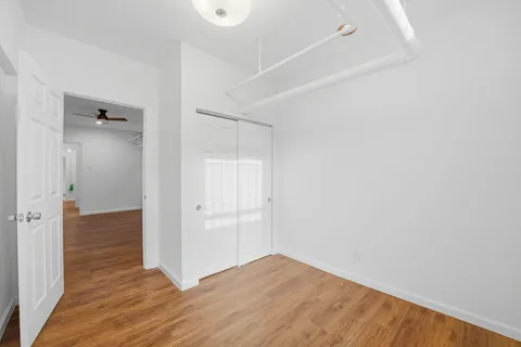a view of an empty room with wooden floor