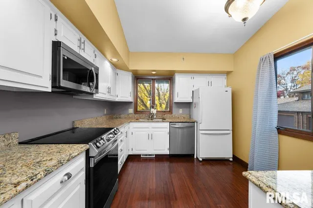 a open kitchen with a sink stove and wooden floor