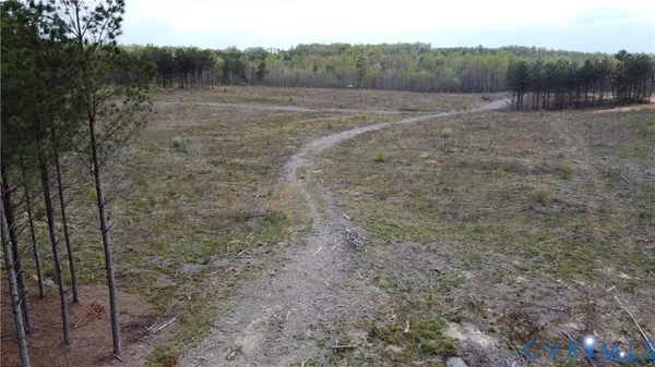 a view of dirt field with trees in background