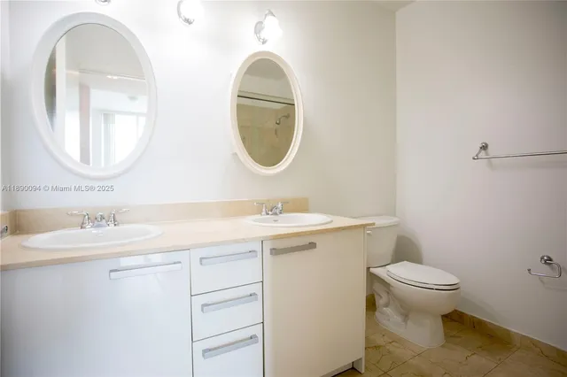 a bathroom with a granite countertop toilet a sink and a mirror