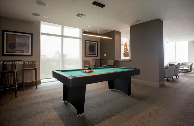 a room with pool table and windows