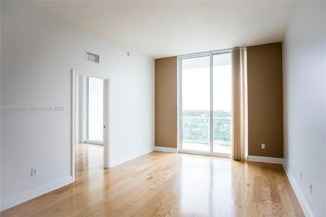 a view of empty room with wooden floor