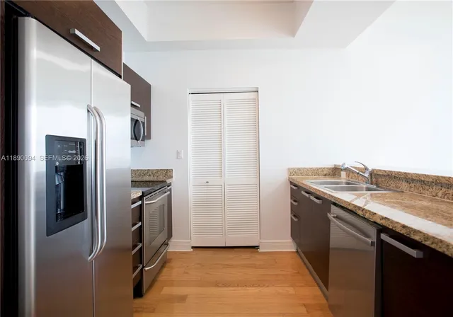 a view of an empty room with wooden floor and closet