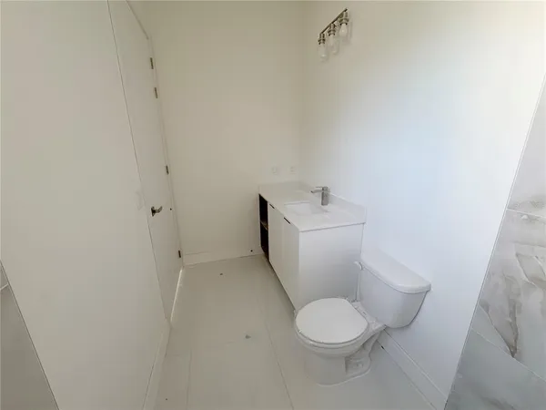 a white toilet sitting next to a white sink