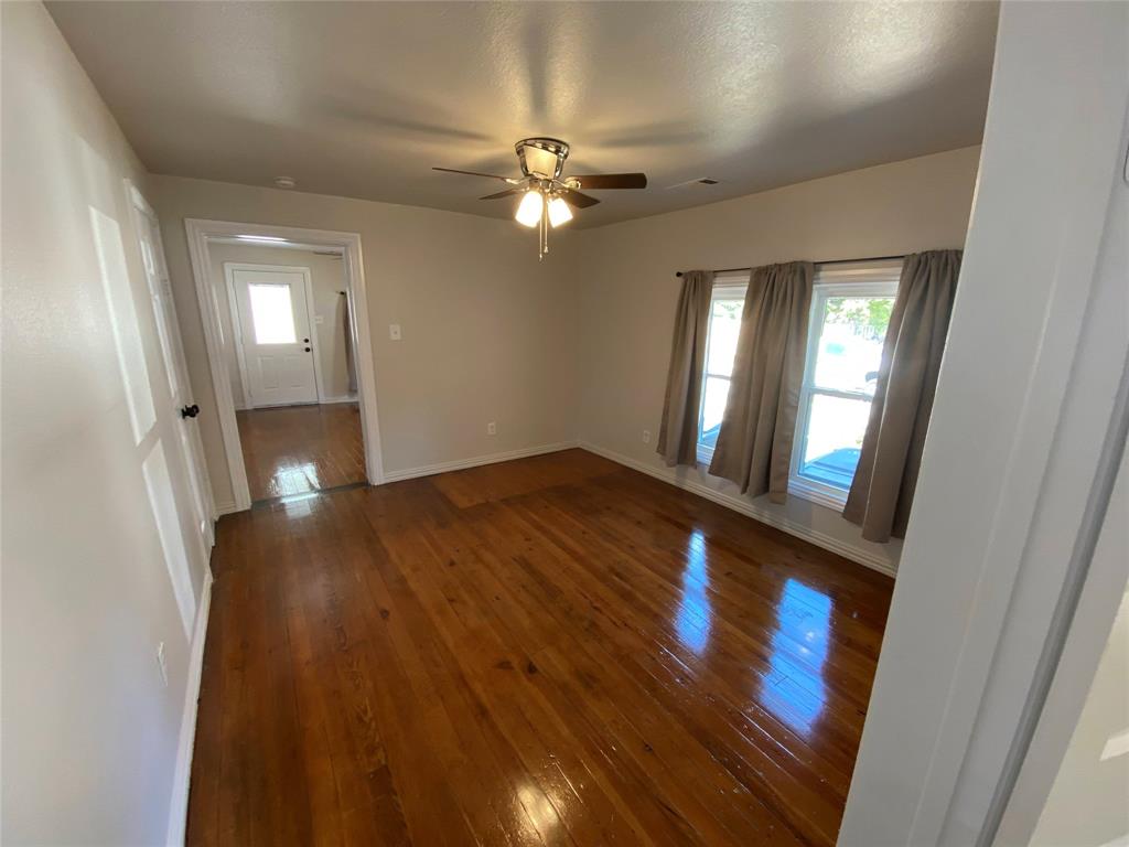 810 Greenville Road McKinney, TX 75069 - Photo 5 of 21 a view of a livingroom with wooden floor and a ceiling fan