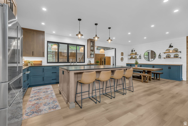 1766 West Tollgate Cyn Road Coalville, UT 84017 - Photo 7 of 59 Open-concept kitchen featuring an oversized island with seating, a stainless steel refrigerator, and wood-finish flooring