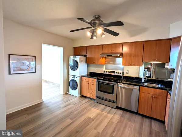 a kitchen with stainless steel appliances granite countertop a stove and a wooden floors