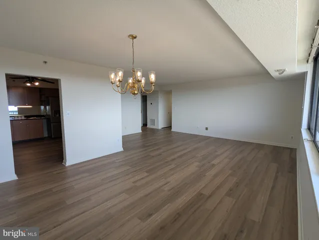 a view of a hallway with wooden floor and closet
