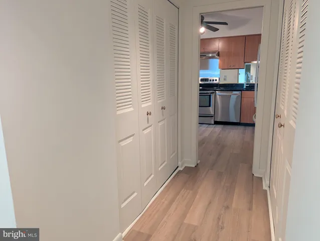 a kitchen with granite countertop a refrigerator cabinets and wooden floor