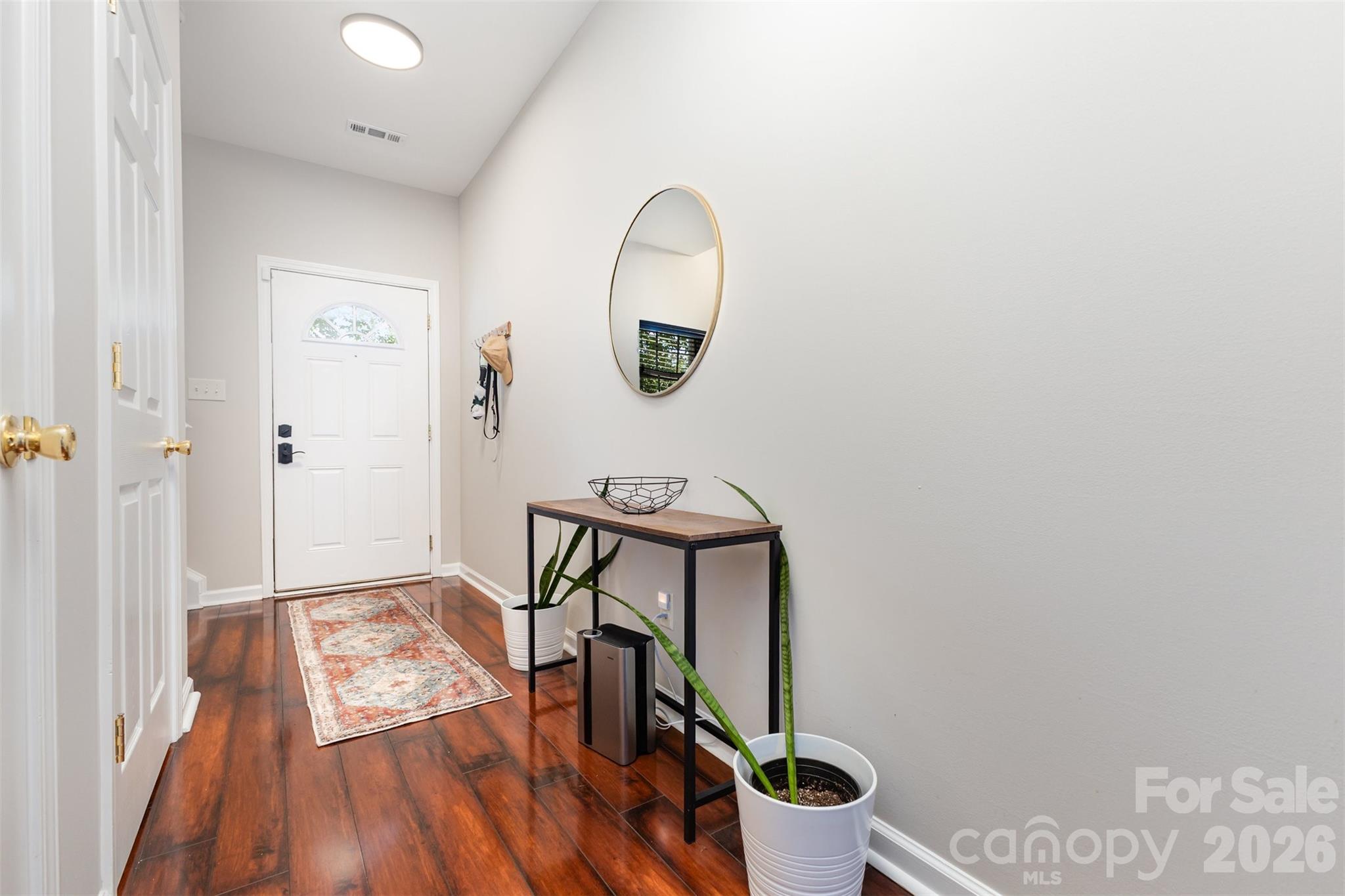 3832 Thomas Ridge Drive Charlotte, NC 28269 - Photo 5 of 33 a view of a hallway with wooden floor and a mirror