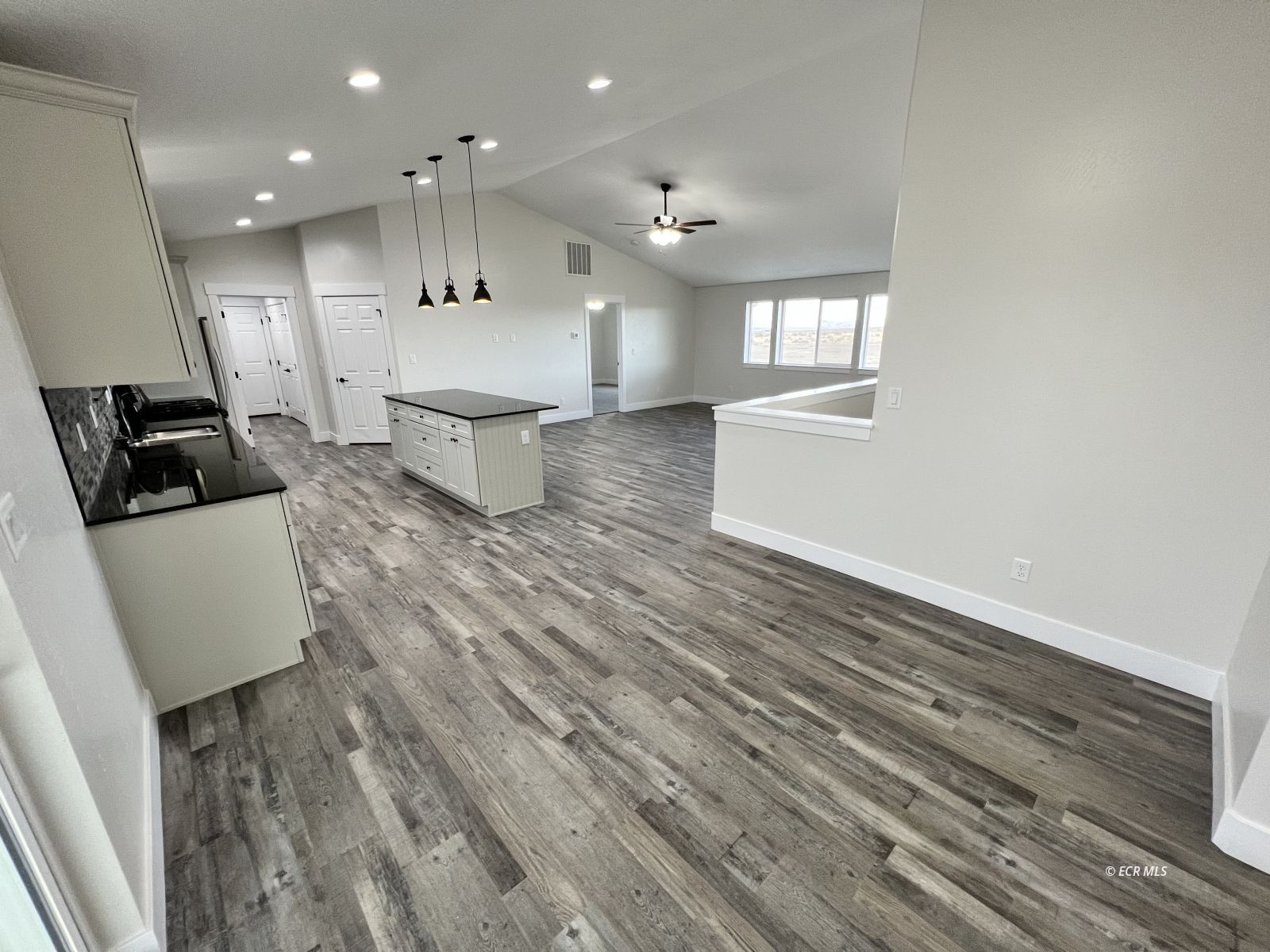 625 Sun Vly Road Spring Creek, NV 89815 - Photo 10 of 38 a large room with kitchen island wooden floors wooden cabinets and stainless steel appliances