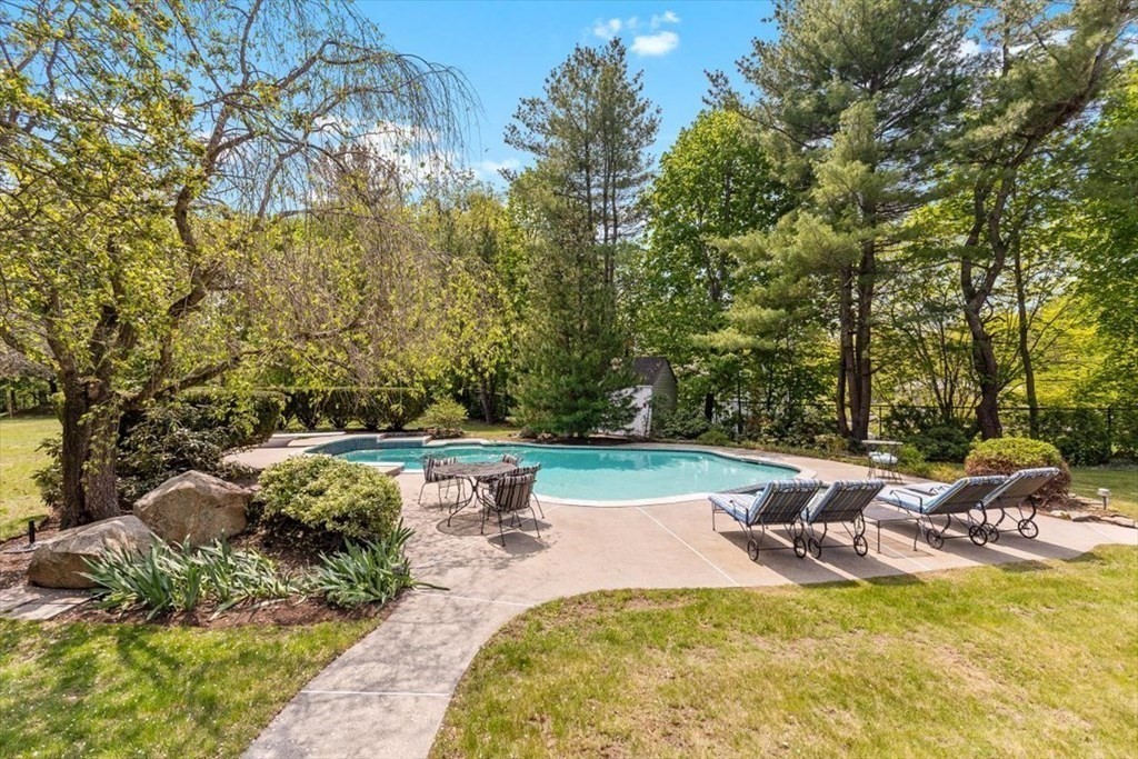 21 Berkley Circle Hingham, MA 02043 - Photo 22 of 34 a view of a swimming pool with lawn chairs under an umbrella