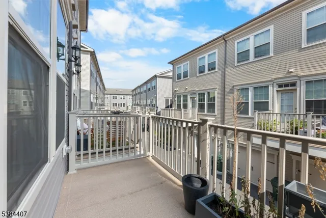 a view of a brick house with large windows and wooden fence