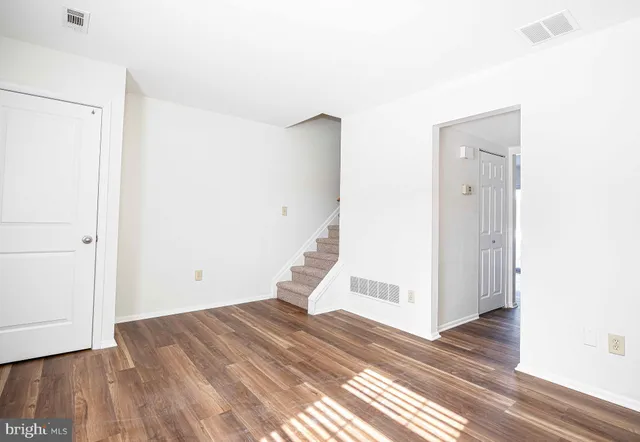 a view of a livingroom with wooden floor and entryway