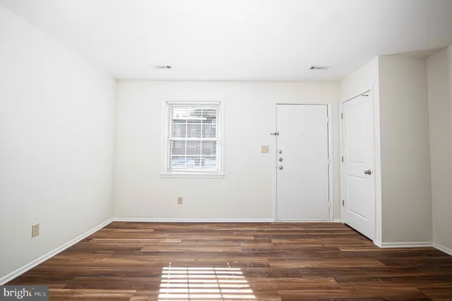 a view of a livingroom with wooden floor and a window