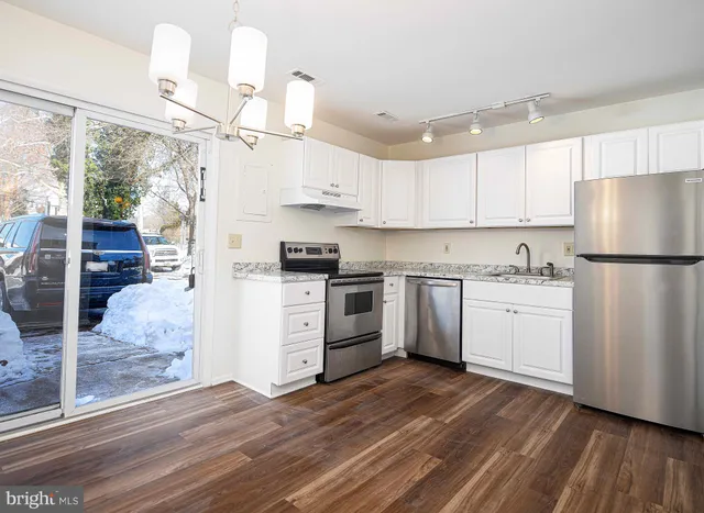 a kitchen with white cabinets and white appliances