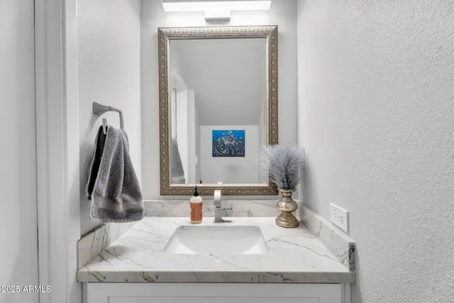 a bathroom with a granite countertop sink and a mirror