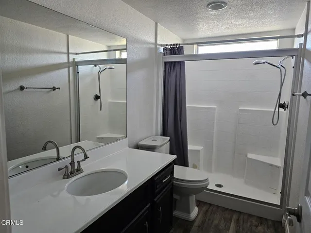a bathroom with a sink a toilet and shower