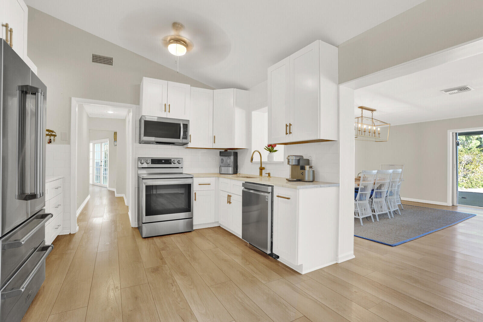 12980 Prosperity Farms Road Palm Beach Gardens, FL 33410 - Photo 12 of 55 a kitchen with a refrigerator stove and white cabinets