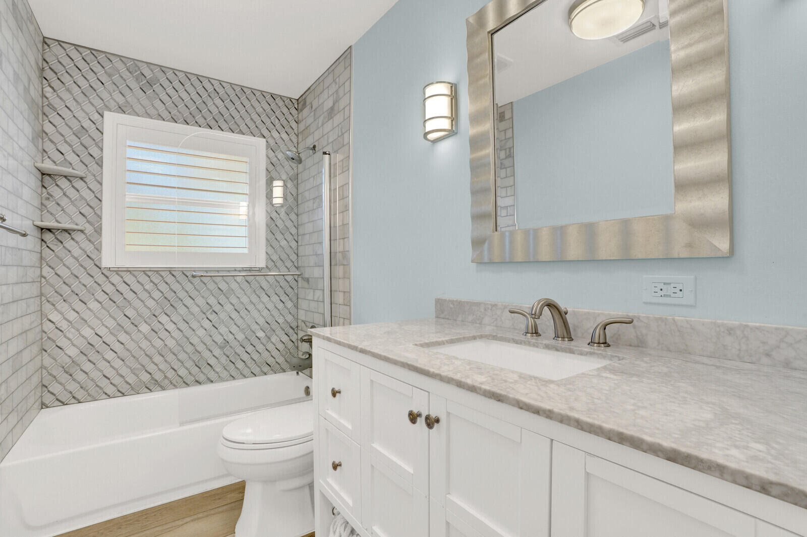 12980 Prosperity Farms Road Palm Beach Gardens, FL 33410 - Photo 32 of 55 a bathroom with a granite countertop toilet a sink a mirror a bathtub and shower